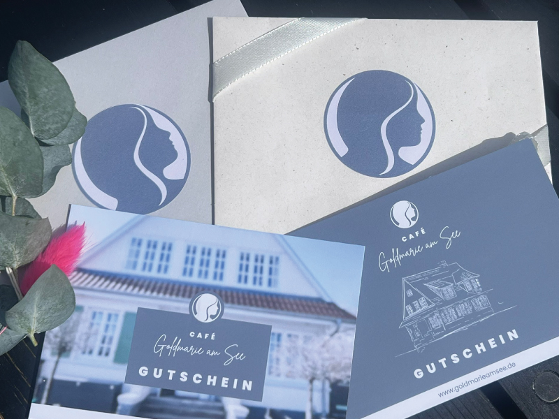 Zwei Gutscheine für das Café Goldmarie am See in einem Umschlag mit Logo.